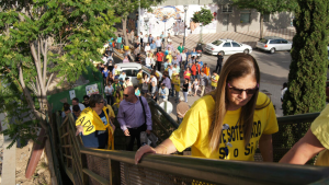 Vecinos y vecinas de la Marea Amarilla suben a la pasarela que cruza las vías del tren./Esther Godoy 